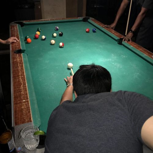Flash photo over a player lining up a pool shot